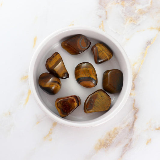 Pierre roulée tigers eye stones polished and displayed in a white bowl by Solstice et Mineraux