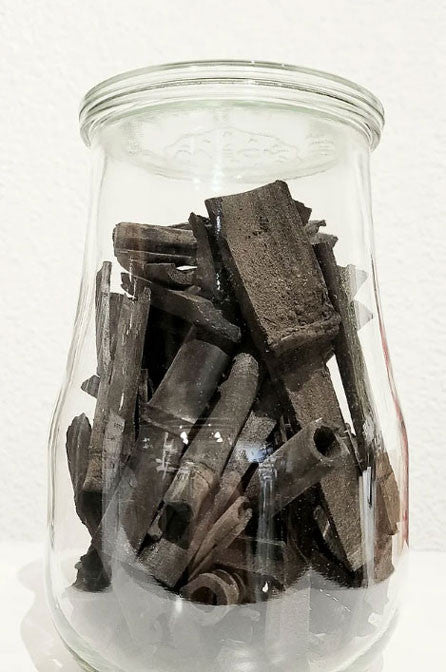 clear glass jar filled with black bamboo and charcoal sticks for odor absorption and air purification
