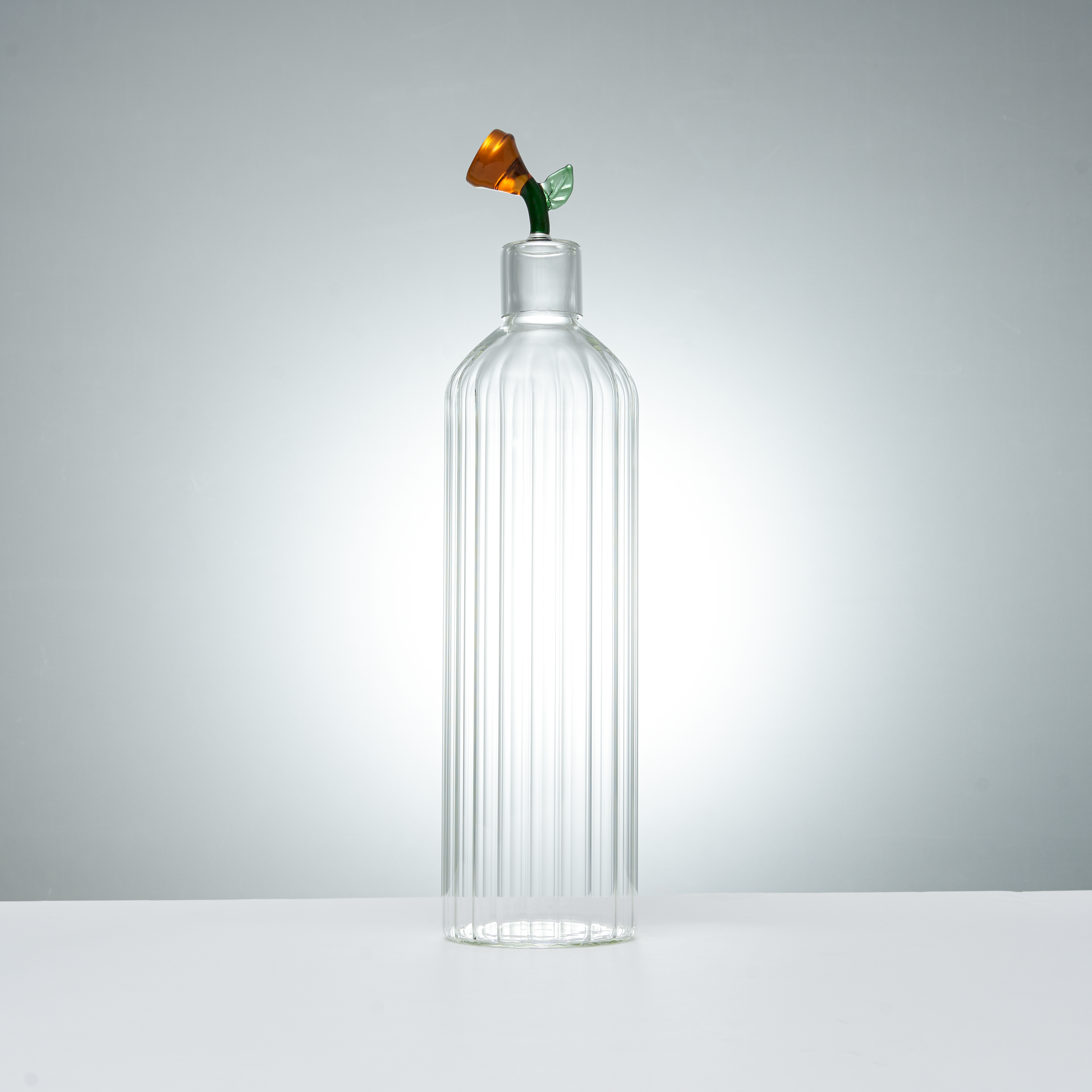 clear ribbed glass carafe and glass with decorative amber flower stopper for serving drinks