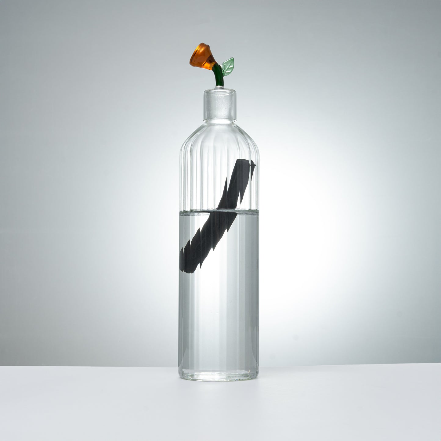 clear glass carafe and glass with orange flower stopper for elegant beverage serving