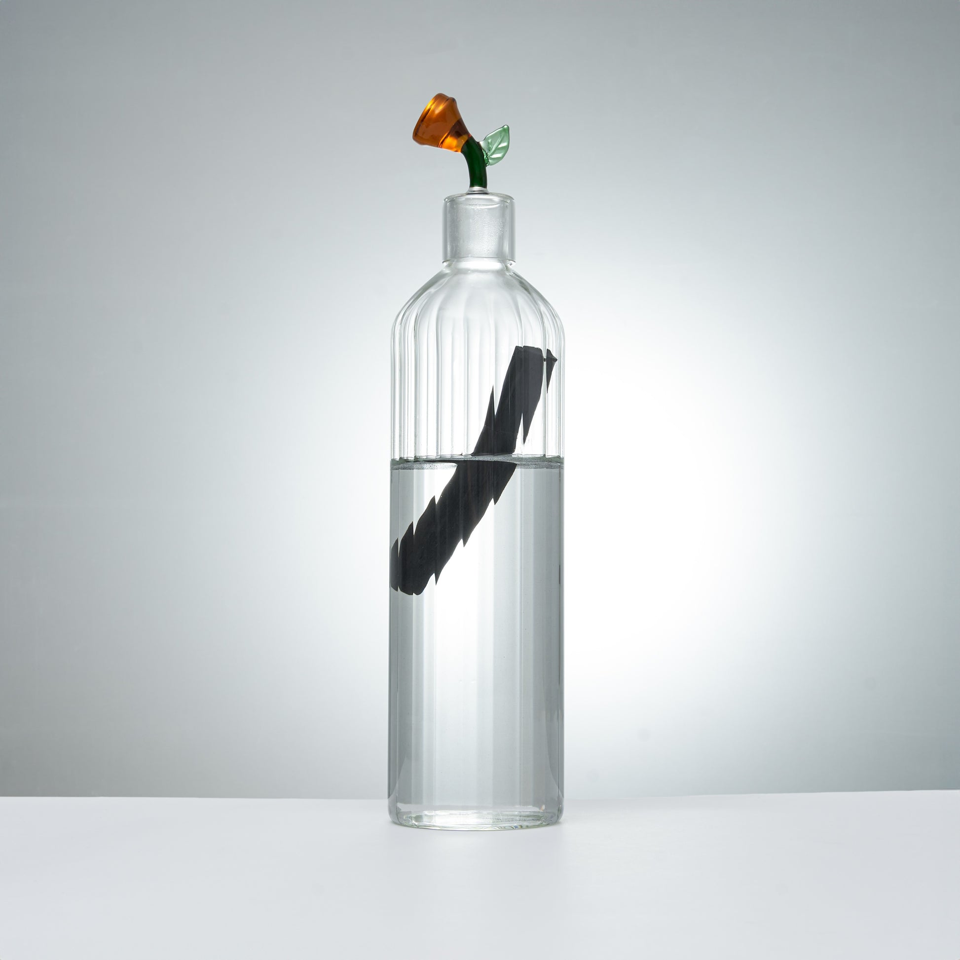 clear glass carafe and glass with orange flower stopper for elegant beverage serving